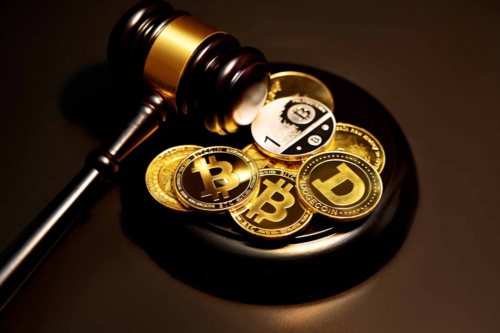 Gavel resting on a pile of various cryptocurrency coins.