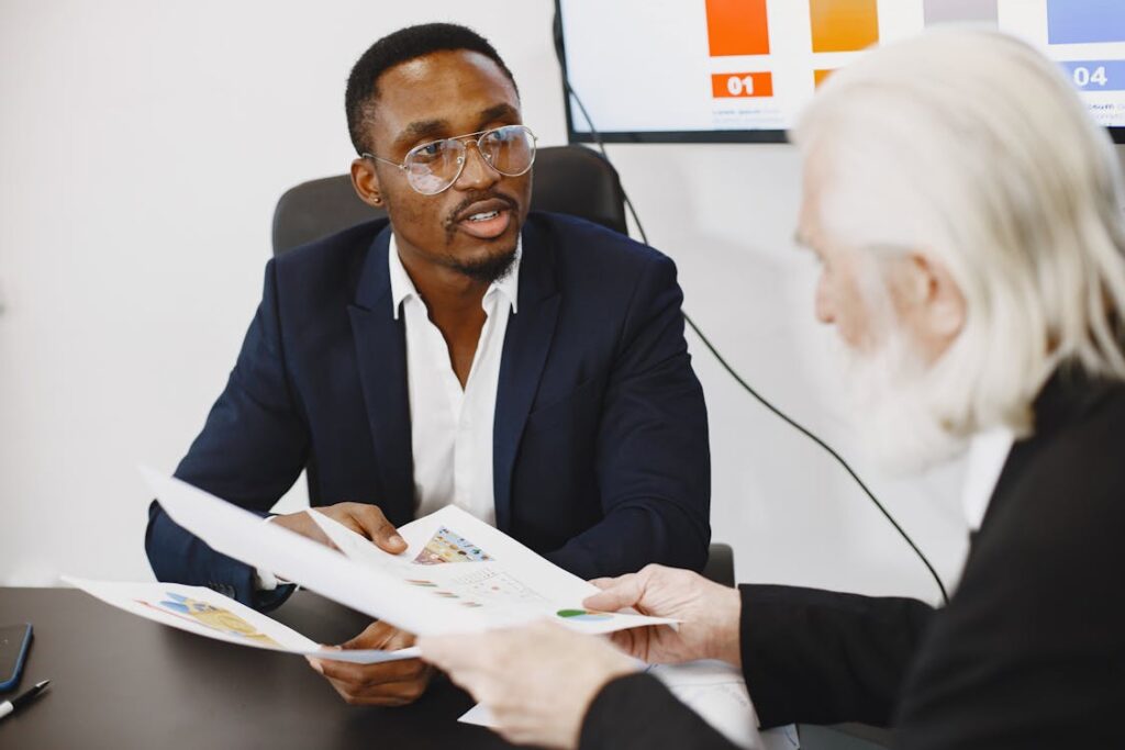 Two cryptocurrency investment consultants discussing documents in an office setting.