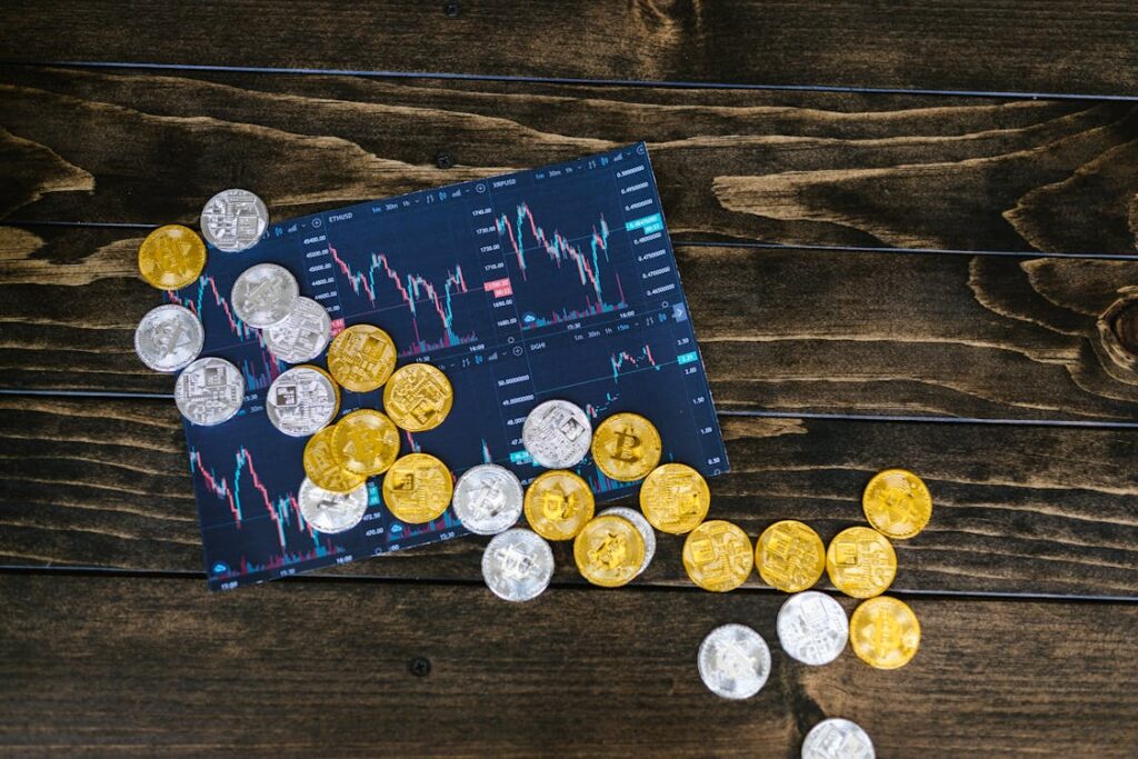 Cryptocurrency coins scattered on a tablet screen displaying financial charts.